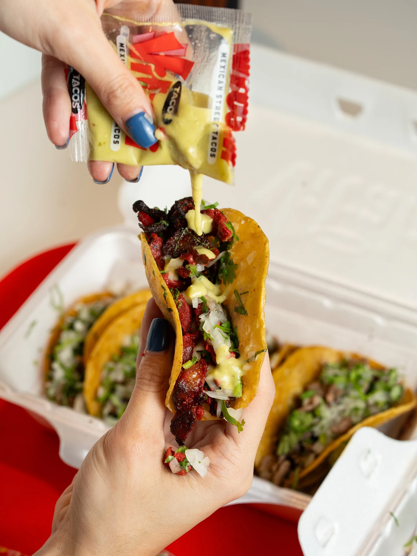 A Vitali trompo taco finished with salsa from a branded packet